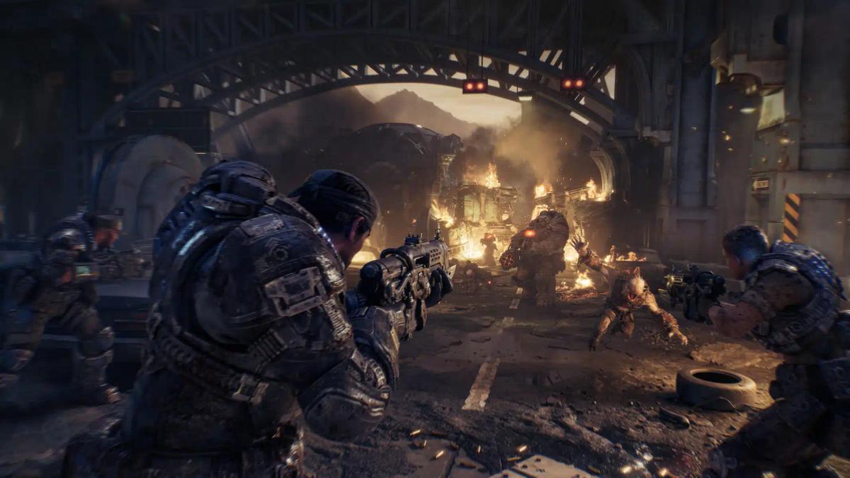 Soldati in armatura pesante che combattono mostri in un ambiente urbano in rovina da Gears of War: E-Day.