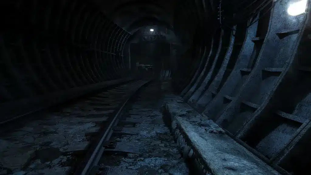 Una vista cupa e suggestiva di un tunnel della metropolitana abbandonato con supporti metallici arrugginiti e luci soffuse.